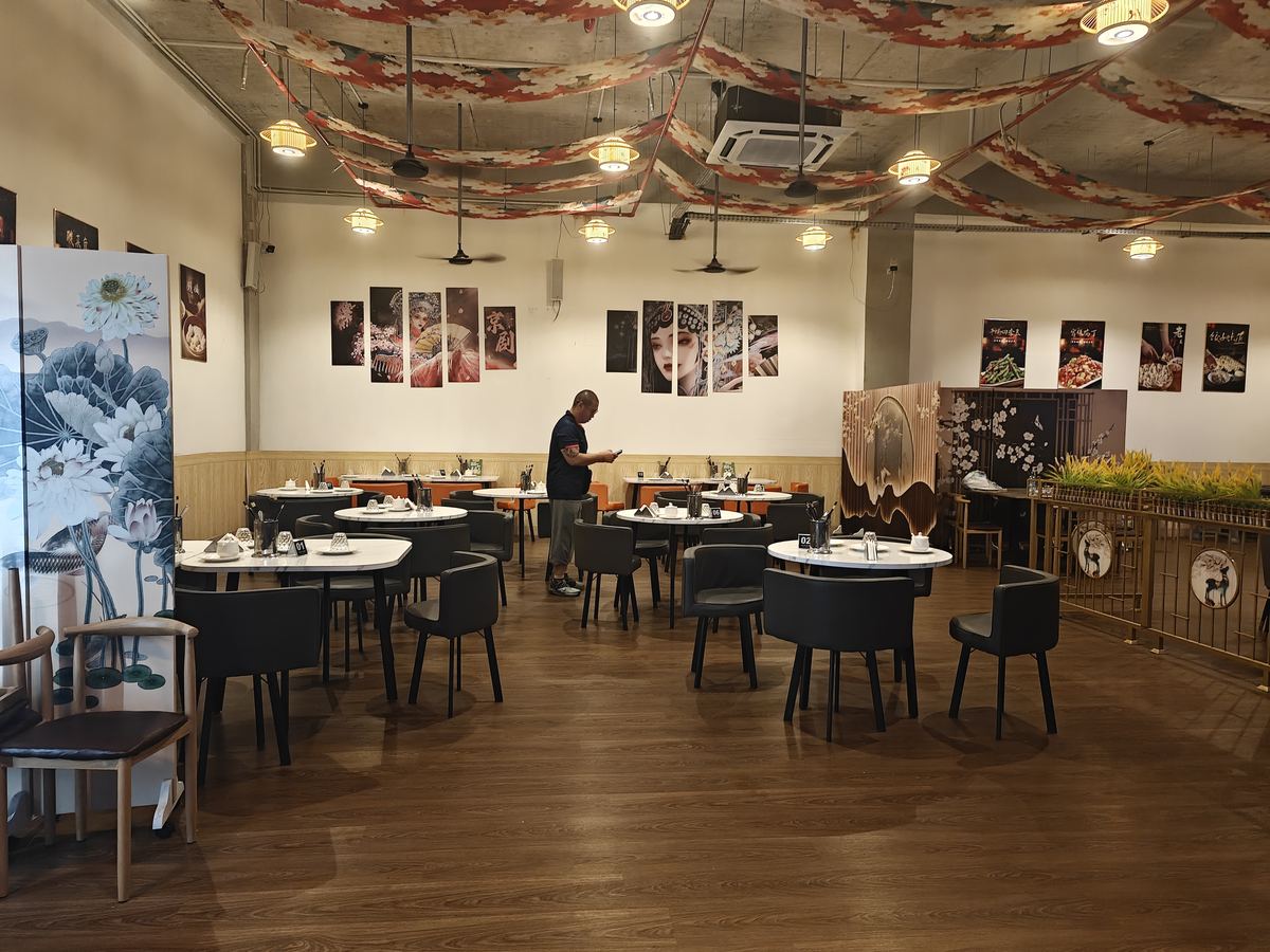 Spacious indoor dining room with round tables and grey chairs